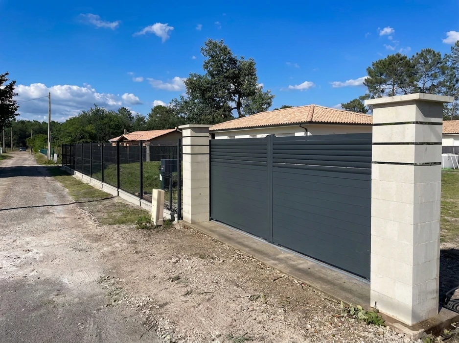 Terrasse extérieure moderne avec lame de bois composite IPE, pergola métallique noire à structure tubulaire, baie vitrée aluminium coulissante sur façade enduit blanc
