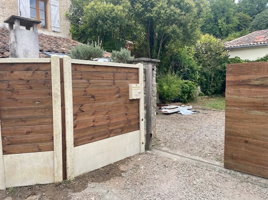Terrasse extérieure moderne avec lame de bois composite IPE, pergola métallique noire à structure tubulaire, baie vitrée aluminium coulissante sur façade enduit blanc
