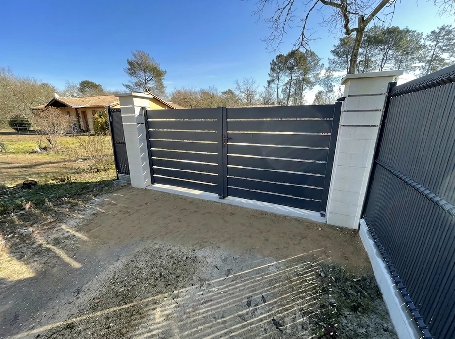 Terrasse extérieure moderne avec lame de bois composite IPE, pergola métallique noire à structure tubulaire, baie vitrée aluminium coulissante sur façade enduit blanc